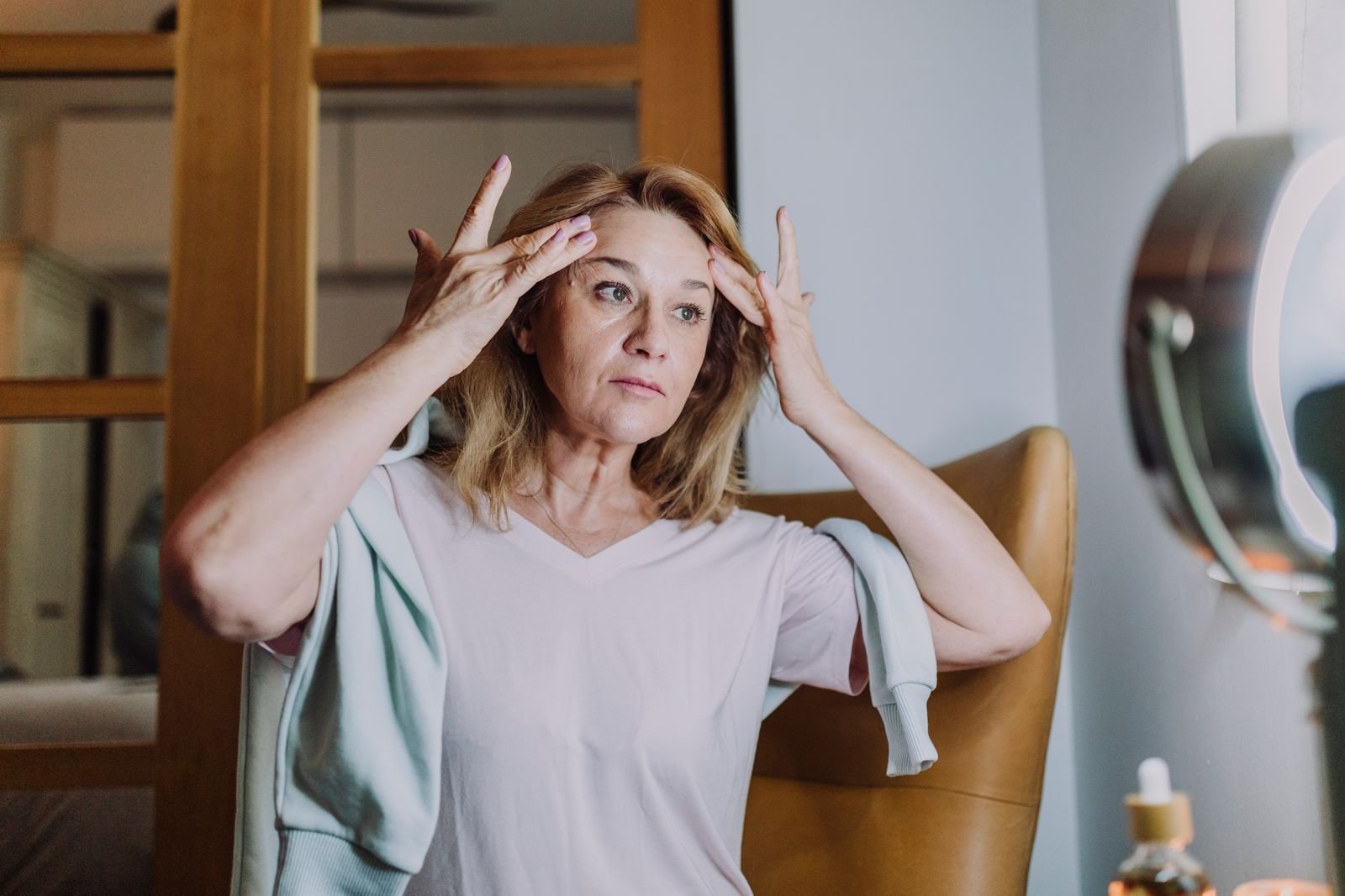 Middle-aged woman gently massaging her face during a simplified skincare routine